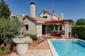 a house with a swimming pool in front of a house at Villa Anja in Pražnice