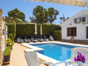 a swimming pool with chairs and a house at VH CostaBlanca - FONDA in Casas de Torrat