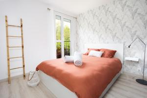 - une chambre avec un lit et une couverture orange dans l'établissement LeCosyMelunais : Parking gratuit + Balcon aménagé, à Melun