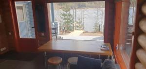 a room with a large window and a table and chairs at Järvenrantamökki Himoksella poreammeella in Jämsä