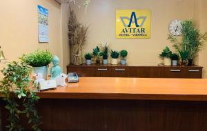 an office with a reception desk with potted plants at Avitar in Rīga