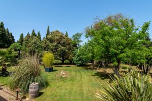 un jardín con árboles y césped y un parque infantil en Domaine de Parazols, en Fabrezan