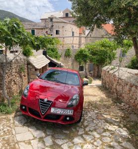 a red car parked in front of a building at Holiday Home Misir in Bol