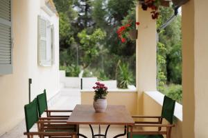 a wooden table with a vase of flowers on a porch at Cottage in the Nature by Konnect, Agios Markos Ipsos in Ágios Márkos