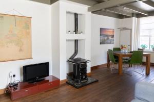 a living room with a television and a table with a fireplace at Museumhuisje 013 in Tilburg