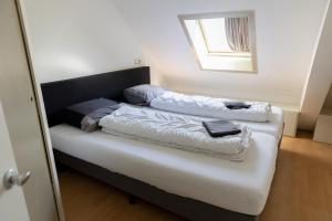 ein Bett mit zwei Kissen auf einem Zimmer in der Unterkunft Museumhuisje 013 in Tilburg