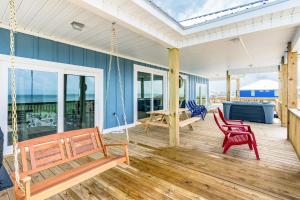 een veranda met 2 stoelen en een schommel bij Dolphin Blue in Dauphin Island