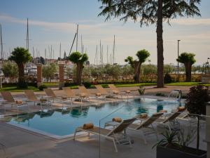 - une piscine avec des chaises longues et beaucoup d'eau dans l'établissement Palazzo Rainis Hotel & Spa - Small Luxury Hotel - Adults Only, à Novigrad