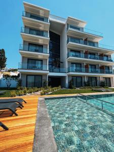 a building with a swimming pool next to a building at KADAGAN SUİTES AYASARANDA in Çeşme