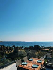 a table on a balcony with a view of the ocean at KADAGAN SUİTES AYASARANDA in Çeşme