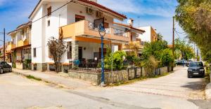 a building on a street with cars parked in front of it at Zoli house in Pefkochori