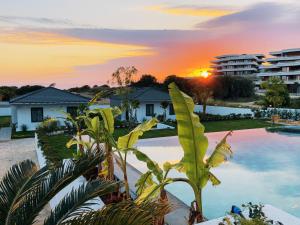 a view of a resort pool with a sunset in the background at KADAGAN SUİTES AYASARANDA in Çeşme