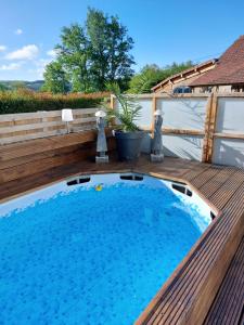 une grande piscine sur une terrasse en bois dans l'établissement Arc de l'amour, à Youx