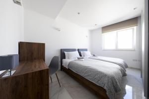 - une chambre avec un lit, un bureau et une fenêtre dans l'établissement Luxurious 3 bedroom apartment with breathtaking views - MMAI1-1, à San Ġiljan