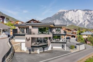 a large house with a mountain in the background at Mountain Moments in Sautens