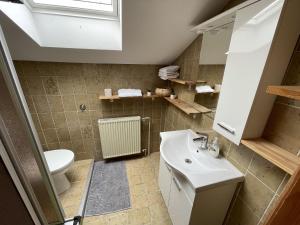 a bathroom with a sink and a toilet at Apartment LakeBled with Casle Bled view in Bled