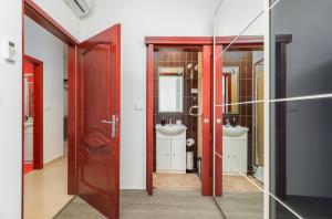 a bathroom with two sinks and two mirrors at Apartment Augusto - Sea view in Pula +31 photos