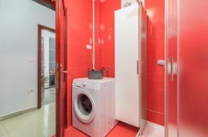 a washing machine in a bathroom with red walls at Apartment Augusto - Sea view in Pula