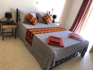 1 dormitorio con 1 cama con 2 toallas en Agréable Villa LuLu sur la côte - La Somone en Ngaparou