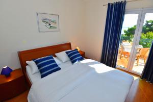 a bedroom with a bed with blue and white pillows at Villa Dalmatina in Živogošće