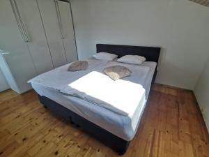 una camera da letto con letto, lenzuola e cuscini bianchi di Apartment LakeBled with Casle Bled view a Bled