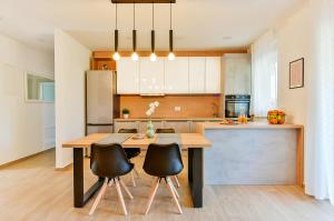 a kitchen with a wooden table and black chairs at Apartment Aura in Poreč