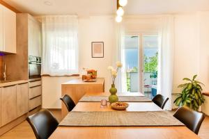 a kitchen and dining room with a table and chairs at Apartment Aura in Poreč +21 photos