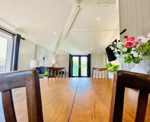 a dining room with a wooden table and flowers at Smart-Home in Original Victorian Building in Bristol