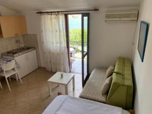 a living room with a couch and a table and a kitchen at Apartmani Ivana in Tivat