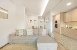 a living room with a couch and a kitchen at Furadouro Beach and Club Apartment in Ovar