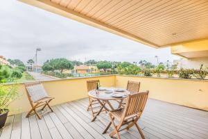 a patio with a table and chairs on a balcony at Furadouro Beach and Club Apartment in Ovar