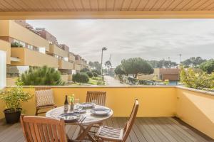 d'une terrasse avec une table et des chaises sur un balcon. dans l'établissement Furadouro Beach and Club Apartment, à Ovar