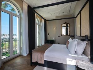 ein Schlafzimmer mit großem Bett und großen Fenstern in der Unterkunft Palazzo Rainis Hotel & Spa - Small Luxury Hotel - Adults Only in Novigrad Istria