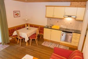 cocina con mesa y comedor en Residence Rosarela, en Badia