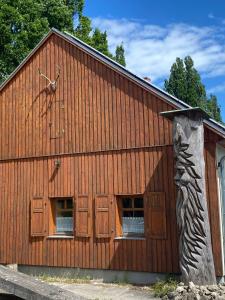 a large wooden building with two windows and a clock at Jagdhaus auf dem Forsthof mit Sauna in Eckartsberga