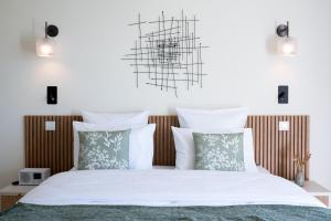 1 dormitorio con 1 cama con sábanas y almohadas blancas en Terre d'Orizon, en Tourrettes-sur-Loup