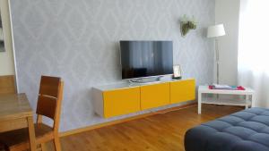 un soggiorno con un mobile giallo con una TV sopra di FeWo Panorama270, Oberstaufen/Steibis a Oberstaufen