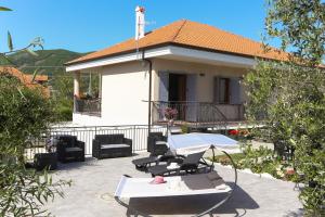 una casa con una mesa y sillas frente a ella en Il Violino degli Dei Holiday House en Agerola