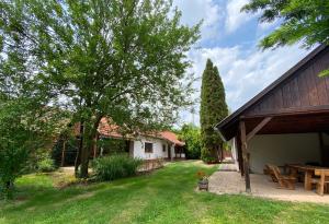 einen Garten mit Picknicktisch und ein Haus in der Unterkunft Hétmérföldes Vendégház in Szaknyér