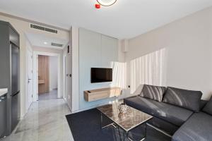 a living room with a couch and a tv at KADAGAN SUİTES AYASARANDA in Çeşme