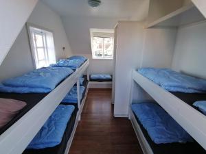 um quarto com 3 beliches com almofadas azuis em Gudhjem Vandrerhjem / Gudhjem Hostel em Gudhjem