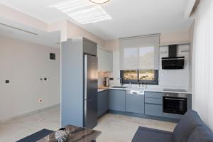 a kitchen with gray cabinets and a window at KADAGAN SUİTES AYASARANDA in Çeşme