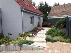 a garden with a brick walkway in front of a house at Gite près de Strasbourg Terre d'Helene 42 m2, 3 étoiles, 4-5 personnes in Berstett +30 photos