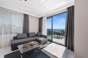 a living room with a couch and a large window at KADAGAN SUİTES AYASARANDA in Çeşme