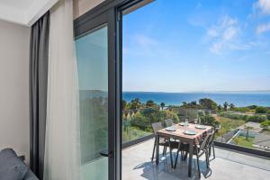 a balcony with a table and chairs and a view of the ocean at KADAGAN SUİTES AYASARANDA in Çeşme
