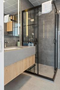 a bathroom with a glass shower and a sink at KADAGAN SUİTES AYASARANDA in Çeşme