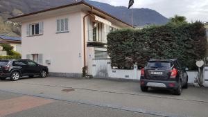 two cars parked in a parking lot in front of a house at Appartamento Elisabetta in Gordola