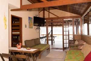 a living room with a couch and a table at Casa 1 - Você a Varanda e o Mar na Praia dos Ranchos-Trindade Hospeda in Trindade