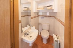a white bathroom with a toilet and a sink at Apartamento La Merced. in Guadalajara