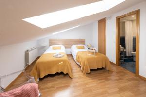 1 Schlafzimmer mit 2 Betten und gelben Decken in der Unterkunft Apartamento La Merced. in Guadalajara